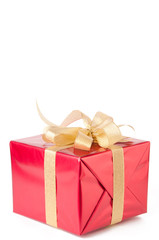Red gift box wrapped with golden bow, isolated over white