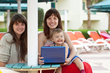 happy women with laptop   at resort hotel