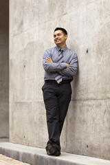 Fototapeta na wymiar Hispanic Businessman - Leaning On Concrete Wall