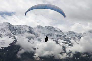 Hang-glider against snowy peaks in Swiss Alps
