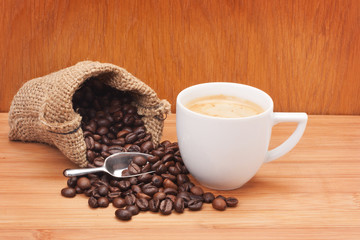 Coffee cup with burlap sack of roasted beans