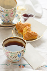 Romantic breakfast with tea, jam, butter and scones