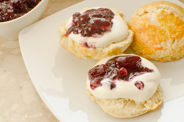 Scones with whipped cream and blackcurrant jam