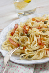 Fresh homemade pasta with bacon, caper and bread crumbs