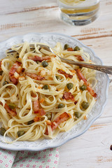 Fresh homemade pasta with bacon, caper and bread crumbs