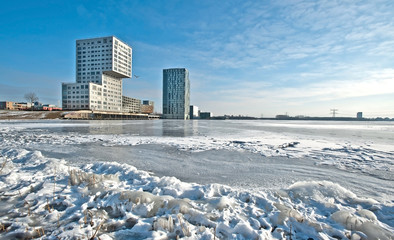 Obraz premium Apartments along a frozen lake in winter