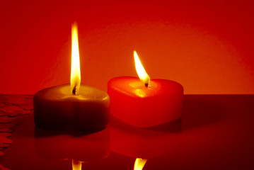 Two burning heart shaped candles