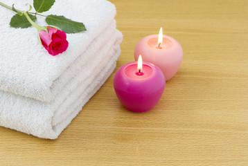 Fototapeta na wymiar White towels with pink candles and red rose spa concept