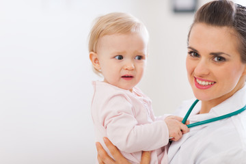 Portrait of pediatrician doctor with distrustful baby