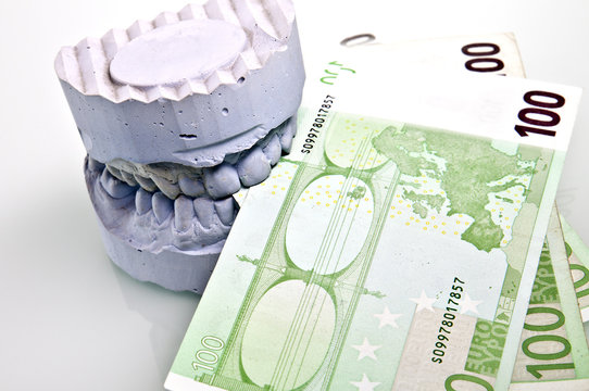 Zahnprothese Kosten Gebiss beißt auf Geldscheine
