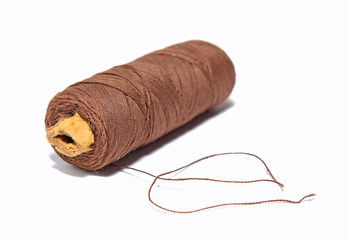 spool  brown threads on white background