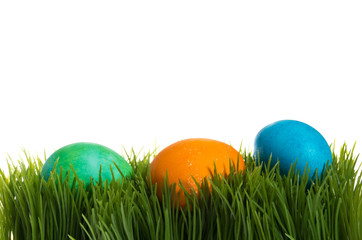Fototapeta na wymiar Three dyed Easter eggs in the grass