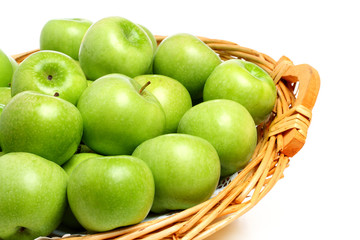 Granny Smith apples on a wicker tray, isolated on white