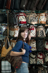 Fototapeta na wymiar woman chooses bag at shop