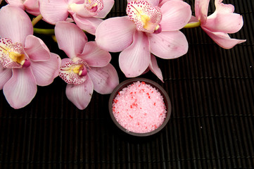 bath salt in a bowl and flowers of orchids on mat