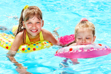 Child sitting on inflatable ring.