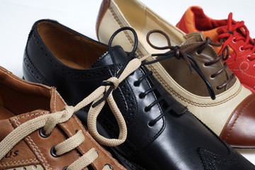 Verschiedene Schuhe aneinandergeschnuert als Symbol fuer Bindungen jeglicher Art