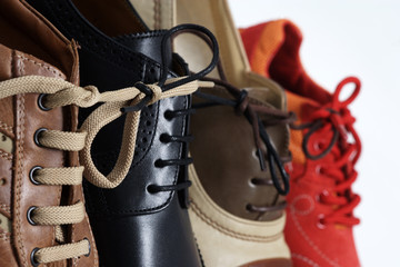 Verschiedene Schuhe aneinandergeschnürt, Symbol für Bindung