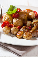 Rustic meat dish with oven baked vegetables and mushrooms