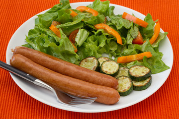 fried sausages with salad and vegetables