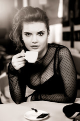 Charming sexy  woman in black clothes  sits at magnificent cafe
