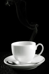 coffee cup over the table against black background
