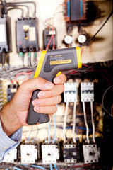 technician holding industrial laser thermometer