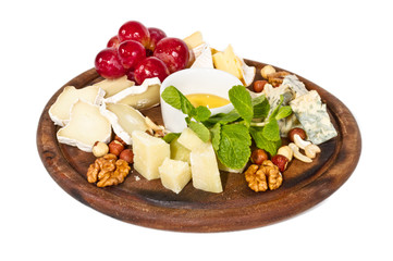 Various types of cheese with honey, nuts and grapes on plate, is