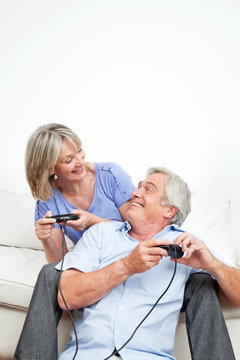 Lachende Senioren spielen Videospiel