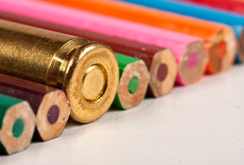 One gun bullet together with pencils