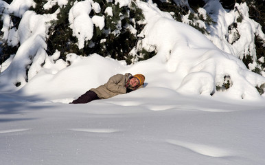 Young girl sleeping in snowy pine trees