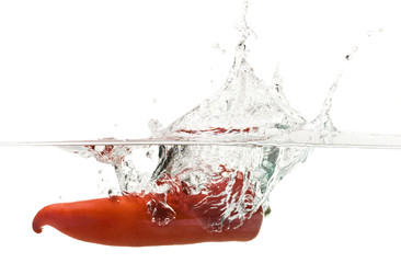 Red pepper splashing into water isolated on white