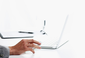 Businessman inserting a cd on white laptop