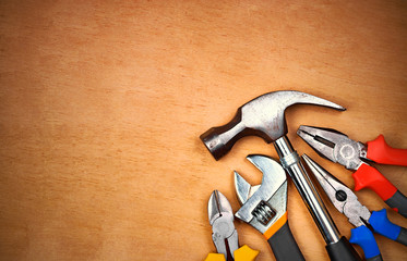 Set of manual tools over a wood panel