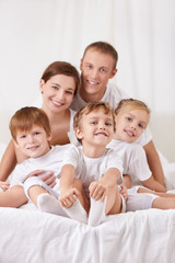 Smiling family with children in bed