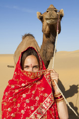 Young women wearing a saree holding a camel the Thar Desert