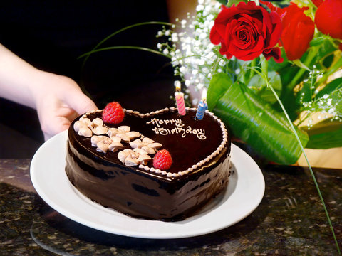 Female Hands Holding  Chocolate Heart Cake And Roses