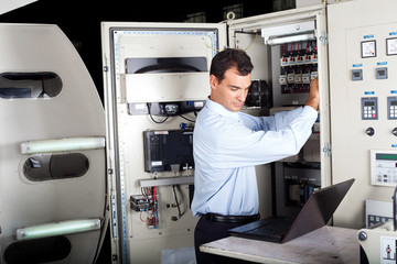 industrial technician repairing modern computerized machine