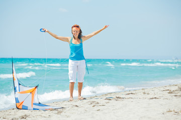 Woman on beach playing with a colorful kite