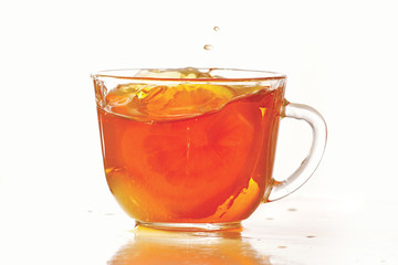 Cup of ice tea and lemon with splash on a white background