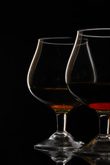 Two glasses of cognac on black background