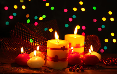 Beautiful candles on wooden table on bright background