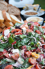 Mixed dressed green salad with bread selection