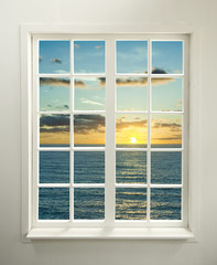 Modern residential window with sunset over sea and clouds