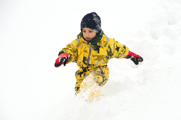 Fototapeta na wymiar Young boy having fun running in the snow.