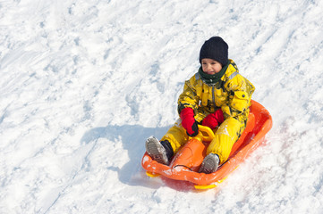 Fototapeta na wymiar Kid sliding with bob in the snow.