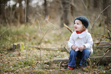 Adorable girl having fun on early spring or autumn