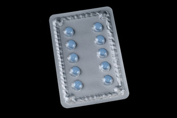 Blue pills on the isolated black background