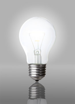 Classic Light bulb turned on isolated on gray with clipping path