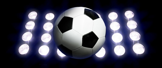 Naklejka premium Soccer ball and spotlights at night